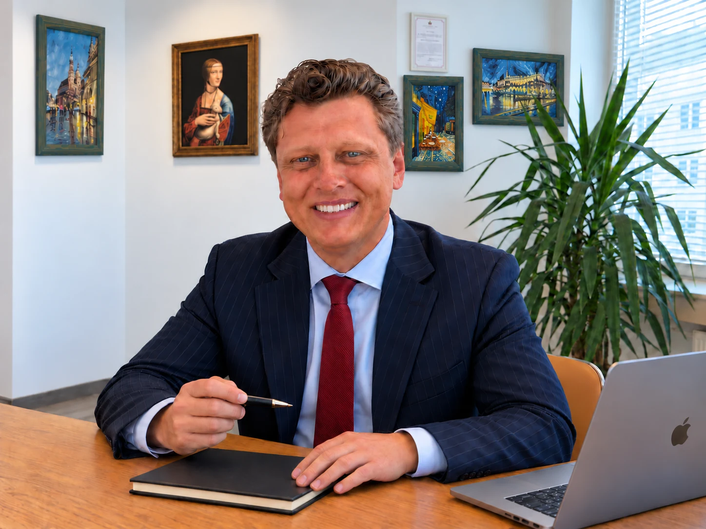 Vadym Rekel trzyma długopis przy zamkniętym notesie; obok MacBook Pro, kancelaria mediacyjna w Krakowie — wizualizacja AI.